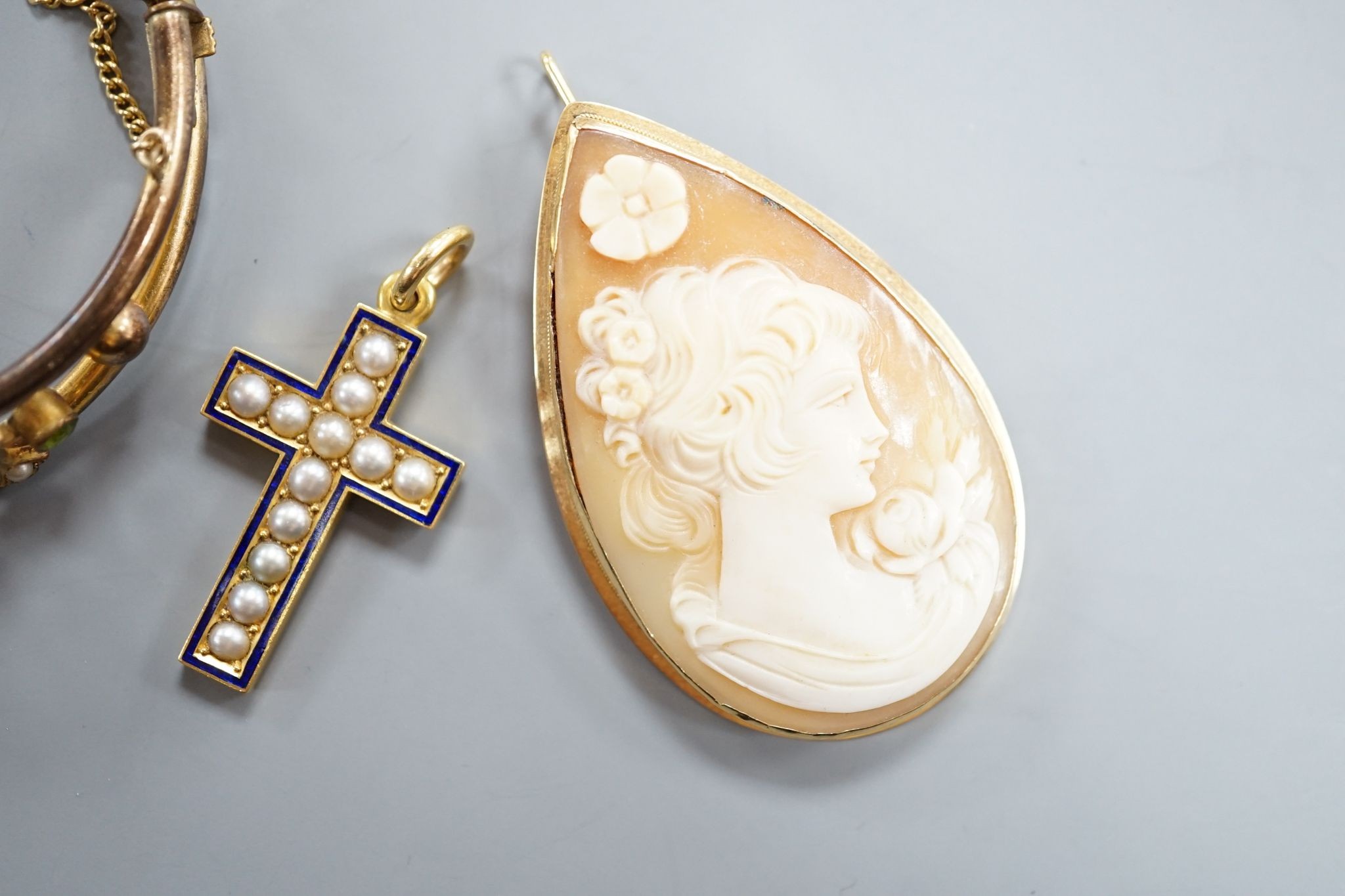 A modern 750 mounted oval cameo shell brooch, 52mm, a yellow metal, split pearl and enamel cross pendant and a paste set gilt metal bangles.